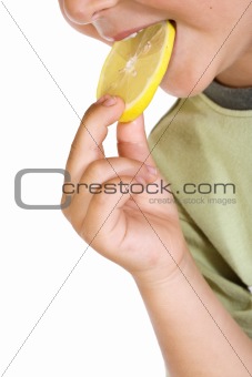 Closeup of child eating lemon slice