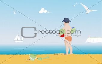 young boy on a beach looking out to sea