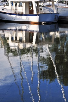 Moored sailboats reflecting in water