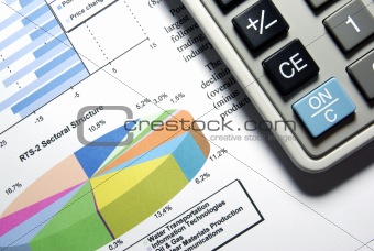 Calculator and printed stock data with diagrams.