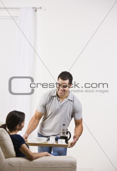Attractive man serving a tray of food to a woman.