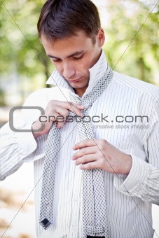 business man making his tie