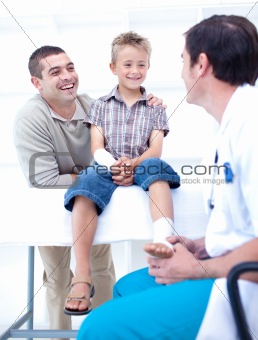 Doctor bandaging a patient's foot with his father