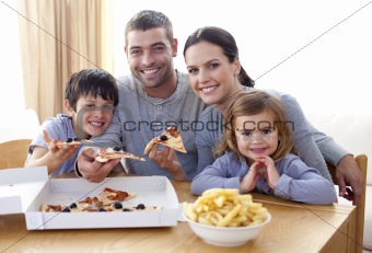 Parents and children eating pizza and fries at home