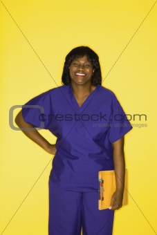 Adult female in medical uniform  holding chart.