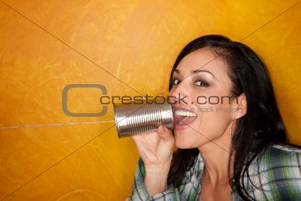 Attractive Hispanic woman with tin can telephone
