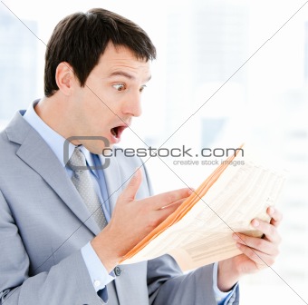 Portrait of a exited businessman reading a newspaper