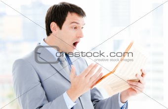 Portrait of a annoyed businessman reading a newspaper 