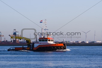 Tugboat with crane passing by on the river