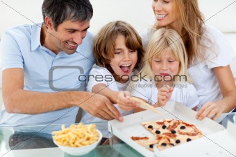 Excited children eating a pizza with their parents