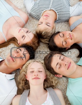 Friends with their heads together sleeping on the ground 