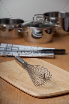 egg beater and pots on a wooden table
