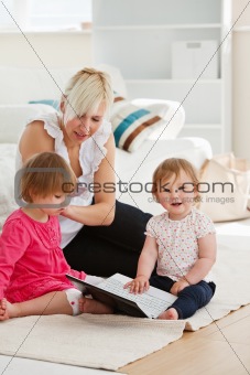 Good-looking woman working with her children at laptop