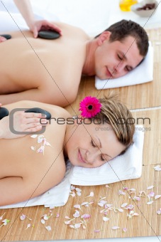 Young couple enjoying a back massage with stone