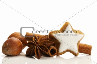 star shaped cinnamon biscuit, cinnamon sticks and hazelnuts