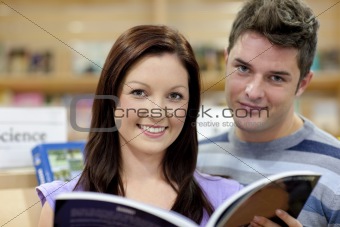 Portrait of a cute couple reading a book in a shop