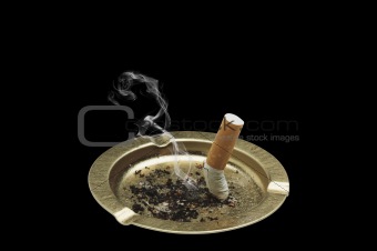 Cigarette and ashtray isolated on black background