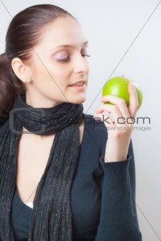 Beautiful young woman holding green apple