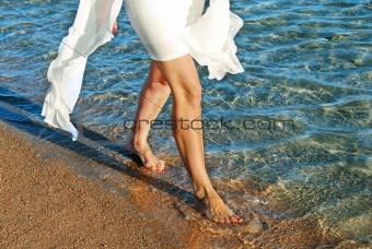 Woman in white dress walking on beach