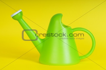Gardening concept with green watering can on background