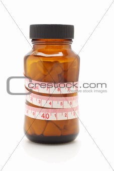 Tape measure and diet pills in glass bottle