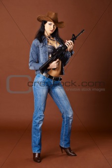 Young woman in jeans holding a rifle