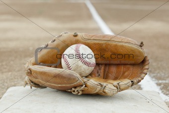 An old worn baseball in a baseball glove