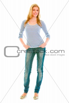 Full length portrait of smiling beautiful teen girl with hands in pockets of jeans
