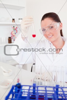 Charming red-haired woman holding a test tube