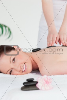 Young redhead woman having a hot stone massage