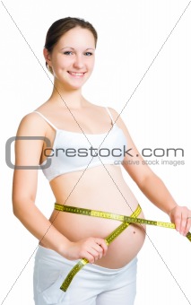 Beautiful pregnant woman measures her stomach