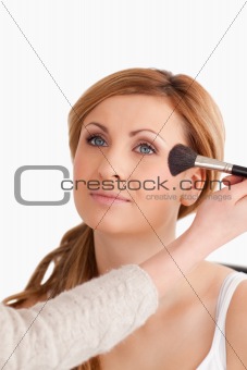 Make-up artist applying make up to an attractive woman