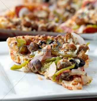 slice of pizza with supreme toppings on a plate
