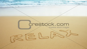 Inscription on beach sand - relax
