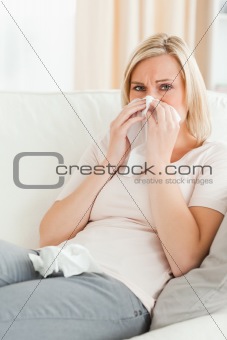 Portrait of a sick woman blowing her nose