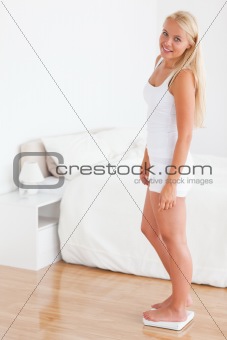 Portrait of a blonde woman on a weighing machine