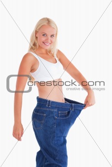 Cute woman wearing to big jeans