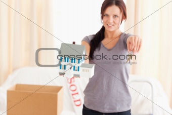 Beautiful woman holding model house and keys