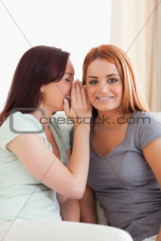 Cute woman being told a secret