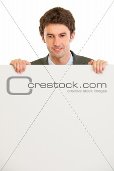 Handsome guy holding blank billboard
