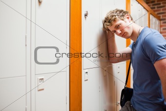 Lonely student leaning on a locker