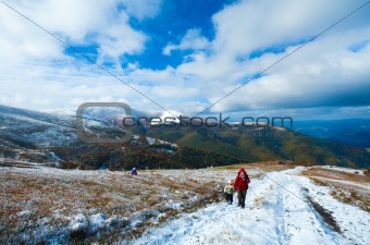 Family on autumn  mountain plateau first winter snow