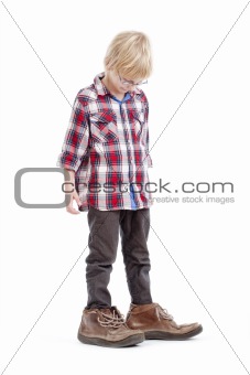little boy wearing his father«s shoes - isolated on white