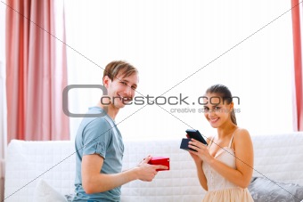 Happy young couple exchanging presents
