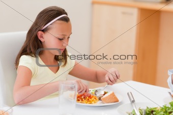 Girl having dinner at the table