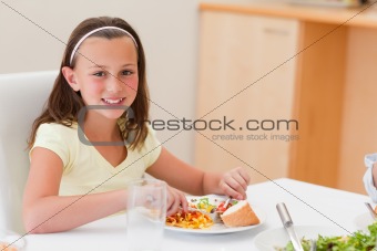 Smiling girl having dinner at dinner table
