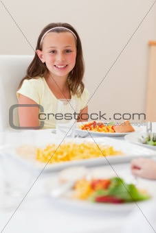 Smiling girl sitting at dinner table