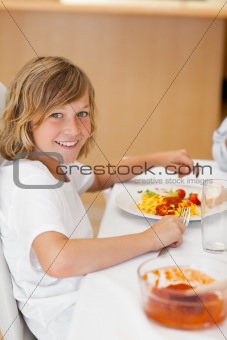 Side view of smiling boy at the dinner table