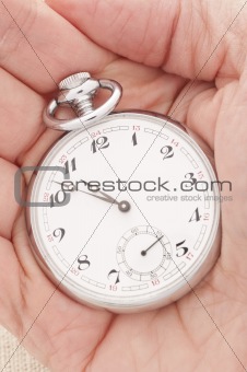 Hand holding an old pocket watch