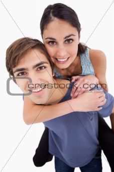 Portrait of a young man holding his girlfriend on his back